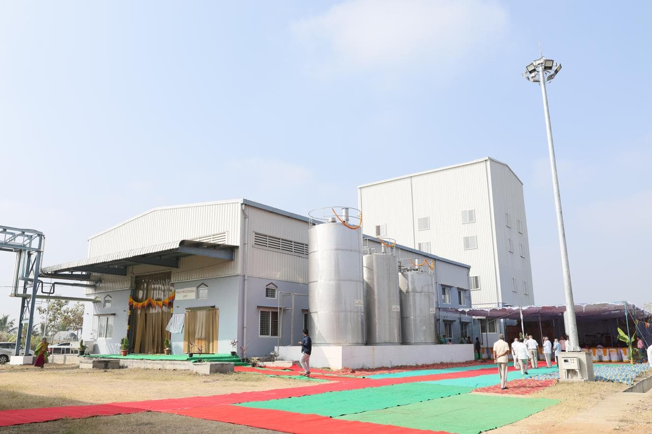 Exterior of the Sri Sathya Sai Gokulam dairy facility with stainless silos
